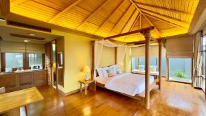 a bedroom with a large bed and a bathroom at Deva Beach Resort Samui in Choeng Mon Beach