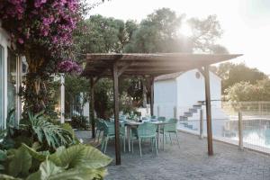un tavolo e sedie sotto un pergolato in legno di CASA BUGANVILLA a Barbate