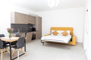 a bedroom with a bed and a table and a kitchen at Residenza Elsa in Domodossola