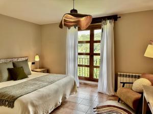 a bedroom with a bed and a large window at L'hotelet d'Estamariu Cal Teixidor in Estamariu +166 photos