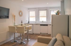 サヴェルヌにあるEntre Ciel et Sable - Centralの冷蔵庫と椅子付きのテーブルがあるキッチン