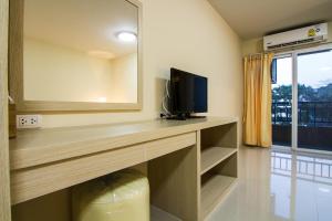 a room with a desk with a television and a window at Dae Ma Place in Nonthaburi
