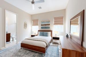 Un dormitorio con una cama, un escritorio y ventanas. en Vista Oasis Retreat, en Cathedral City 30 fotos más