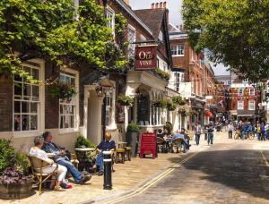 a group of people sitting in chairs on a city street at Central Chic 3 bed, Great Location in Winchester