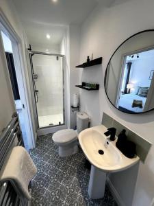 a bathroom with a sink and a toilet and a mirror at Central Chic 3 bed, Great Location in Winchester +25 photos
