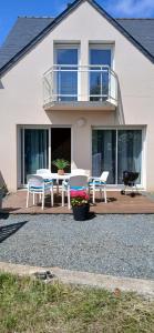 a house with white chairs and a balcony at Angenehmes Haus in Perros-Guirec