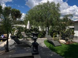 eine Terrasse mit Stühlen, einem Tisch und einem Sonnenschirm in der Unterkunft Villa con Jacuzzi in Ponte Galeria