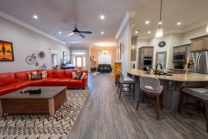 Una sala de estar con un sofá rojo y una cocina. en Insurance Housing Fully Furnished & Stress-free, en Sherwood