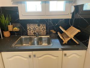 a kitchen counter with a sink and wooden utensils at Arletos Home in Ioannina