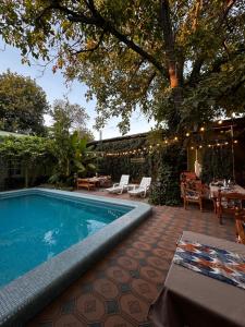 a swimming pool in a yard with a table and chairs at Green Yard boutique guesthouse in Tashkent