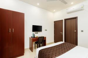 a bedroom with a bed and a desk with a computer at The Lotaz Hotel in Cochin