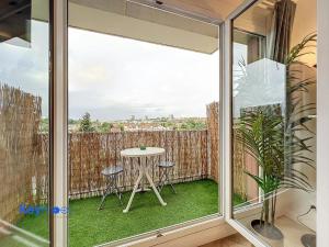 a balcony with a table and chairs and a window at 2 pièces lumineux proche Paris - Parking gratuit in Fresnes