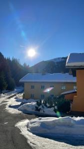 a building with snow on the ground in front of it at Ferienwohnung Bernhardiner in Nauders