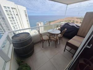 een balkon met een tafel, stoelen en een vat bij Dpto 2 piezas 2 baños al lado de las dunas de Concon in Viña del Mar