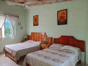 a bedroom with two beds and a window at Hotel Casa Corita in Jala