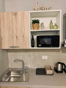 a kitchen counter with a sink and a microwave at Monolocale Romolo in Fucecchio