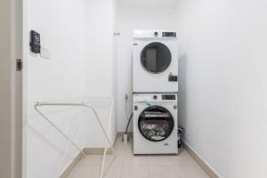 a washer and dryer in a white room at Emerald Hill Kuala Lumpur by HLG in Kuala Lumpur