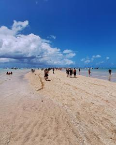 a group of people walking on a beach at Suite da Barra in Barra Grande