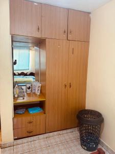 a room with wooden cabinets and a trash can at Ultimate retreat in Embu
