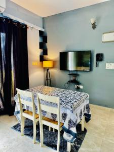 a dining room with a table with two chairs and a tv at Sea breeze 1 bhk apartment A12 Calangute,North Goa in Nagoa-Bardez