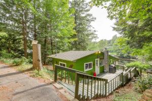 une petite maison verte avec une clôture en bois dans l'établissement Rustic Waterfront Cottage with Fire Pit and Kayaks, à Weare