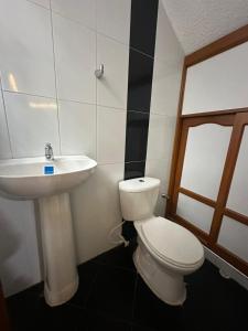 une salle de bain avec des toilettes blanches et un lavabo dans l'établissement Centro Paipa, à Paipa 5 autres photos
