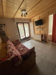 a living room with a couch and a ceiling fan at Appartement 5 personnes in Bellevaux +10 photos