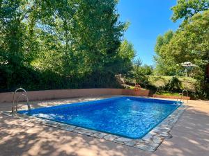 a swimming pool with blue water in a yard at Camping El Madroñal in Fuenteheridos