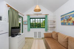 Una sala de estar con un sofá y una ventana. en Private Solarium Bungalow Garden, en Maspalomas
