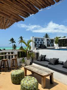 a patio with a table and chairs and the ocean at Hi Zanzibar in Paje