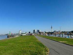 a bike path next to a river with a city at City Studio Kormoran in Bremerhaven
