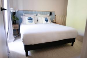 a bedroom with a large bed with white sheets and pillows at La Bastide de Montferrat in Montferrat