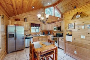 Una cocina con una mesa y un refrigerador de acero inoxidable. en Rustic Charm, en Sautee Nacoochee