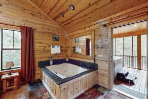 bañera grande en una habitación con paredes de madera en Rustic Charm, en Sautee Nacoochee