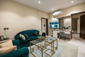 a living room with a green couch and a table at درة العزيزية للشقق المفروشة in AlUla
