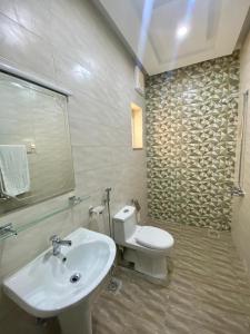 a bathroom with a white sink and a toilet at Dream Inn Guest House Islamabad in Islamabad