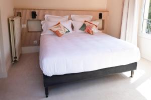 a large white bed with pillows on top of it at La Bastide de Montferrat in Montferrat