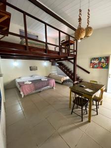 a bedroom with a loft bed and a table at Pousada Sapê in Praia do Frances +49 photos