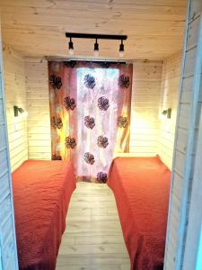 two beds in a small room with a window at Forest edge in Saugos