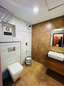 a bathroom with a toilet and a sink and a mirror at Shanthi Tourist Home in Pathanāmthitta +62 photos