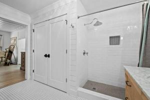 a white bathroom with a shower with a glass door at Private Retreat Burwood 8 acres Hot Tub Fire pit in Spring Hill +29 photos