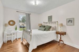 a bedroom with a bed and a desk and a window at Whispering Cottage 3 BRD 2 BA Grill Fire pit in Spring Hill