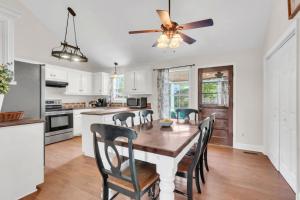a kitchen with a table and chairs and a ceiling fan at Whispering Cottage 3 BRD 2 BA Grill Fire pit in Spring Hill