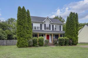 a house with a red door and trees at Vacation N the Station Spacious Cozy 3 bed in Thompsons Station
