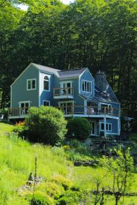 Una gran casa azul situada en la cima de una colina en Vermont Ski Home Lake Home, en Jacksonville