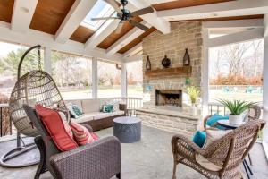 a screened porch with chairs and a fireplace at Birdsong Retreat Hot Tub Grill Fire Pit in Franklin