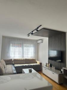 a living room with a couch and a tv at X apartment - Charming 1BR Retreat apartment in Pristina