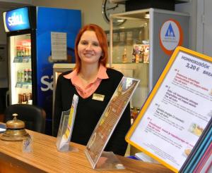 a woman standing behind a counter with a sign at Eurohotel in Maardu