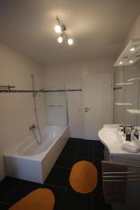 ein Badezimmer mit einer Badewanne und einem Waschbecken in der Unterkunft Appartement Romantikstadt Steyr in Steyr