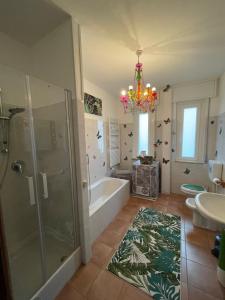 a bathroom with a chandelier and a tub and a sink at B&BMagicHouse in Novara